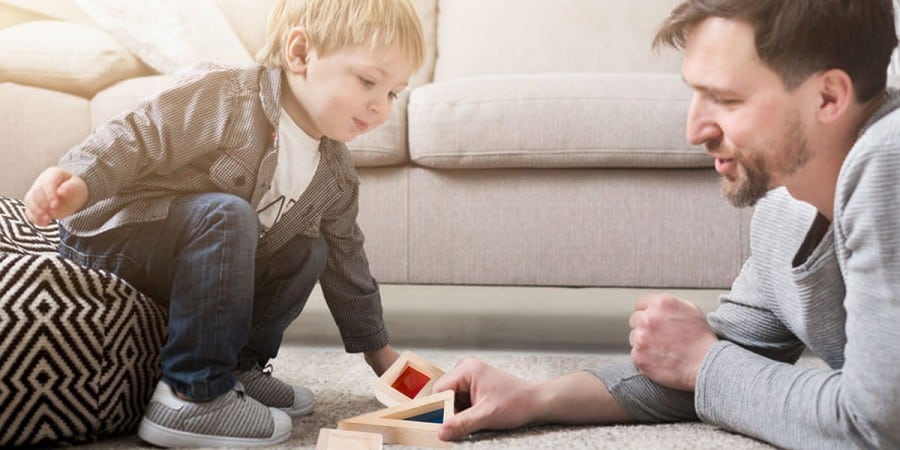 the importance of play-father and son on the floor playing with wooden building blocks