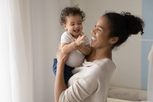 smiling mother and infant; baby is gesturing with hands