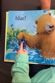 early literacy and language development toddler pointing at book